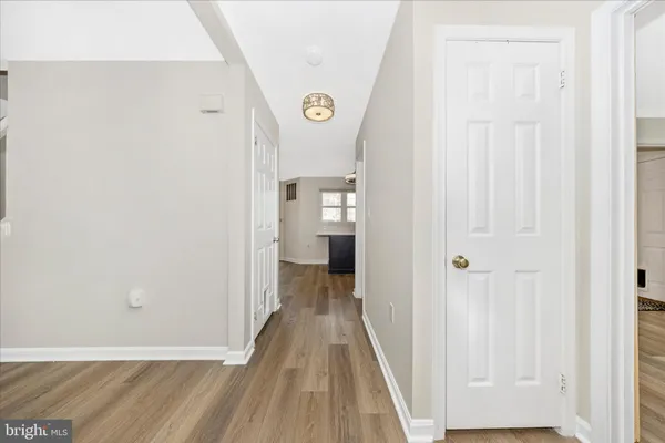 a view of a hallway with wooden floor and entryway