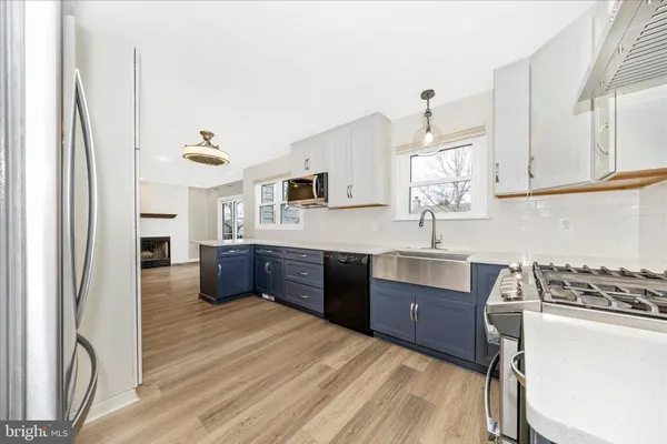 a kitchen with stainless steel appliances kitchen island granite countertop a refrigerator stove and sink