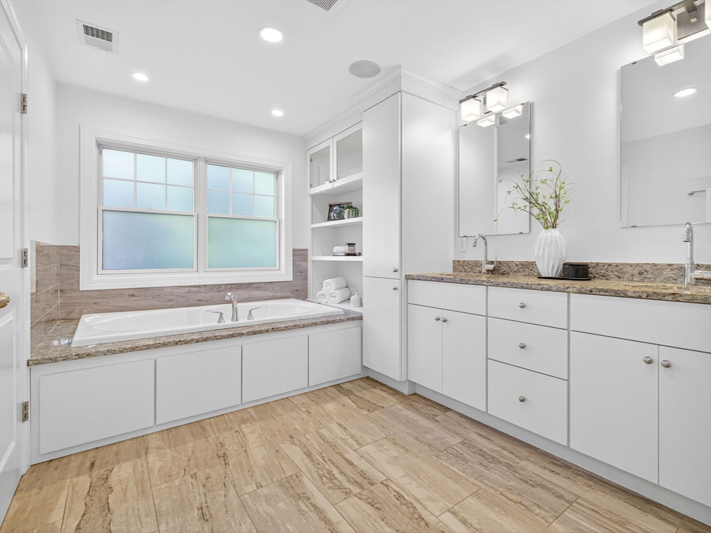 79 Peter Parley Road Boston, MA 02130 - Photo 21 of 38 a large white bathroom with a granite countertop sink mirror and a bathtub