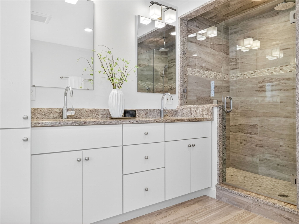 79 Peter Parley Road Boston, MA 02130 - Photo 22 of 38 a bathroom with a granite countertop sink a mirror and a shower