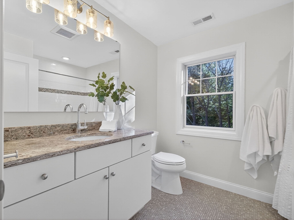 79 Peter Parley Road Boston, MA 02130 - Photo 28 of 38 a bathroom with a granite countertop sink a toilet and a window