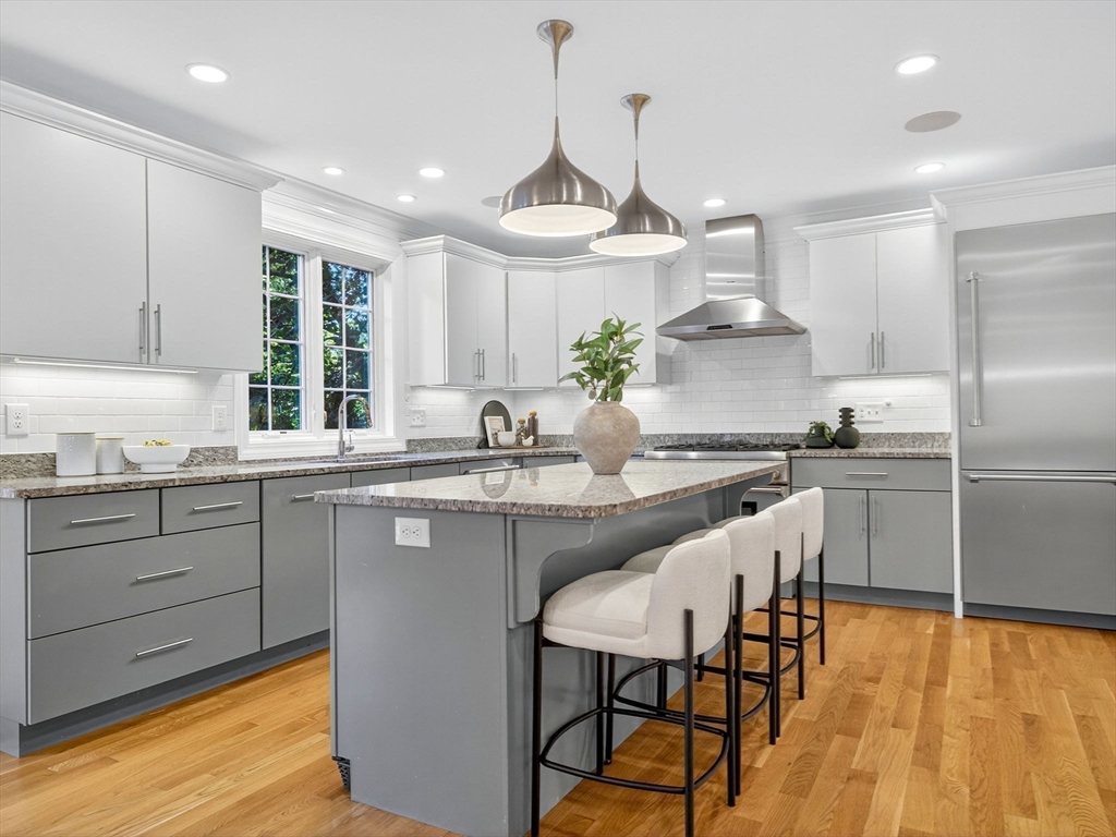 79 Peter Parley Road Boston, MA 02130 - Photo 7 of 38 a kitchen with granite countertop a sink stainless steel appliances and white cabinets