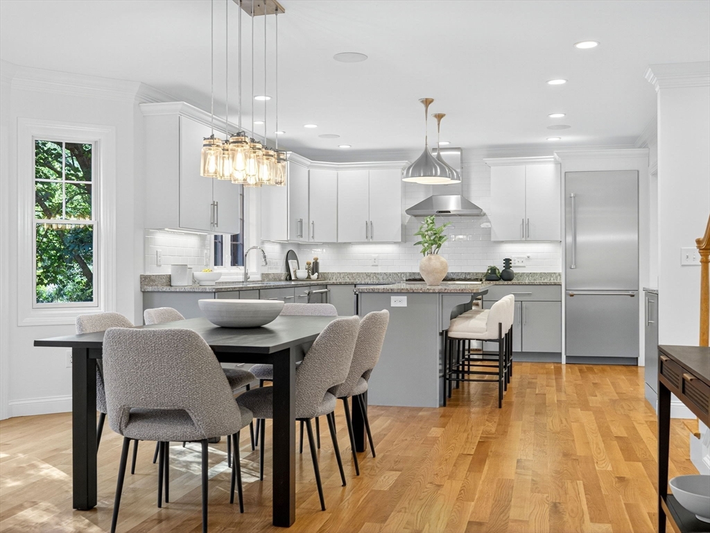 79 Peter Parley Road Boston, MA 02130 - Photo 10 of 38 a kitchen with kitchen island a dining table chairs stainless steel appliances and windows