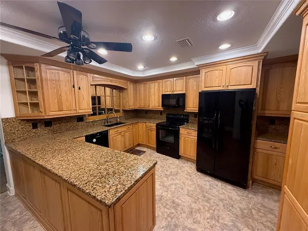 a kitchen with stainless steel appliances granite countertop a refrigerator a sink a stove a microwave and island
