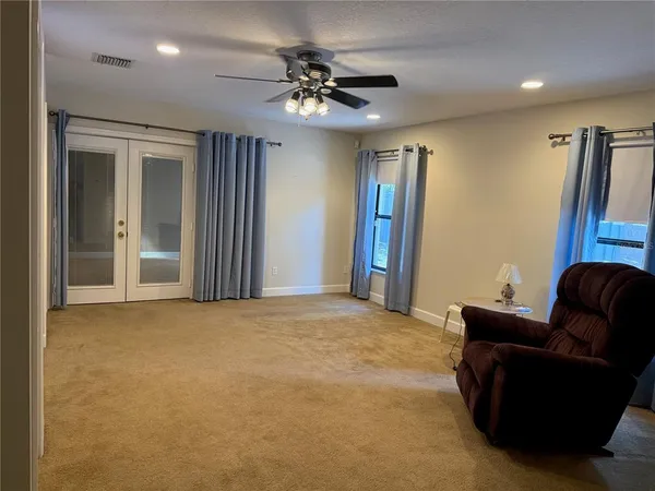 a living room with furniture and a ceiling fan