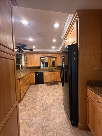 a kitchen with stainless steel appliances granite countertop a refrigerator and a stove