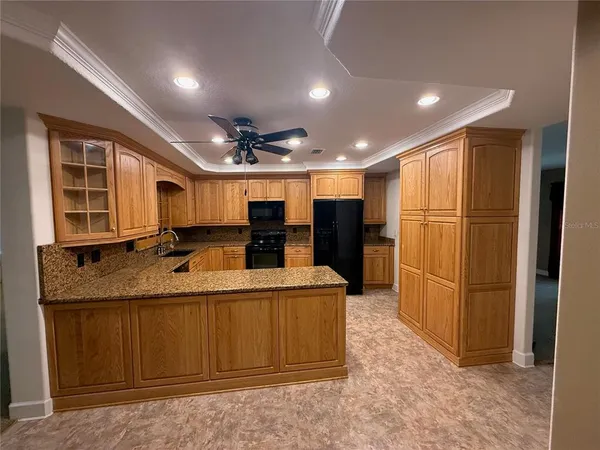 a large kitchen with stainless steel appliances granite countertop a refrigerator and a sink