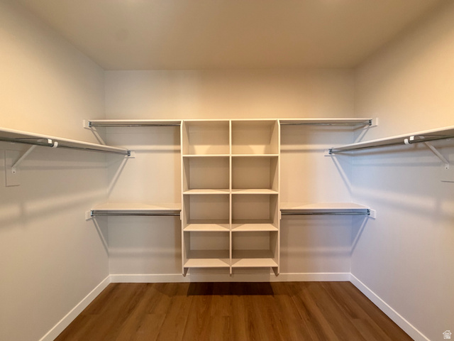 5885 Canyon Rim Road, Unit 624 Lehi, UT 84048 - Photo 12 of 17 Spacious walk-in closet featuring wood-finish flooring, built-in shelving, and multiple hanging rods for comprehensive organization