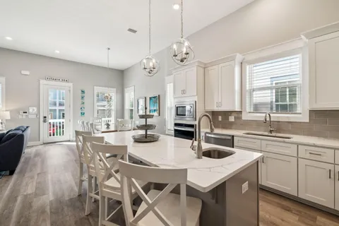 a kitchen with a dining table chairs cabinets and stainless steel appliances