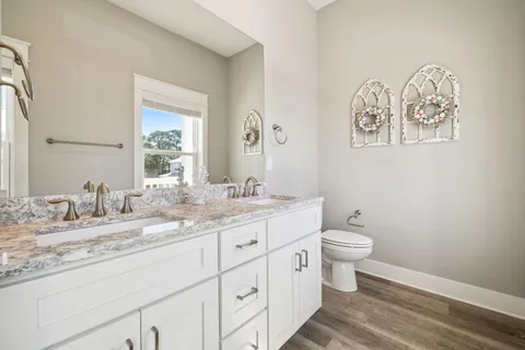 a bathroom with a granite countertop toilet sink and mirror