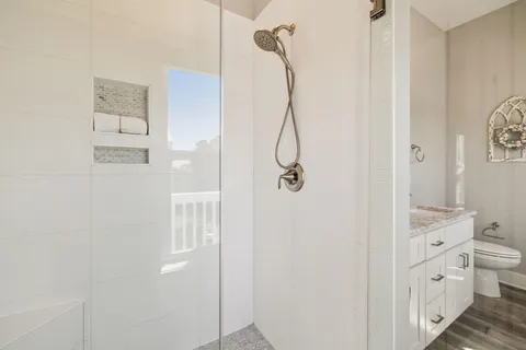 a bathroom with a granite countertop shower sink and mirror