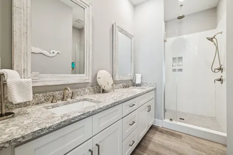 a bathroom with a granite countertop sink mirror and shower
