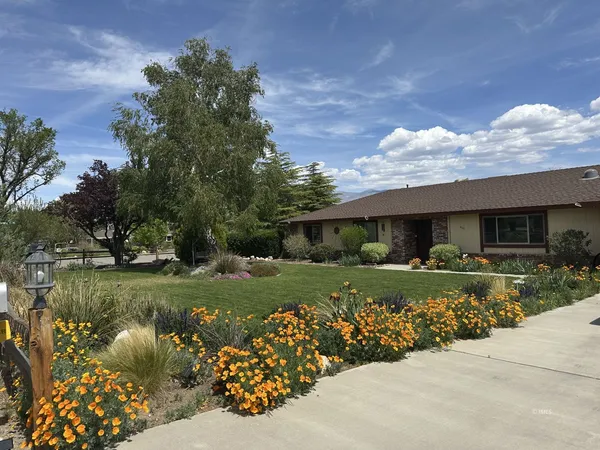 a front view of a house with a garden