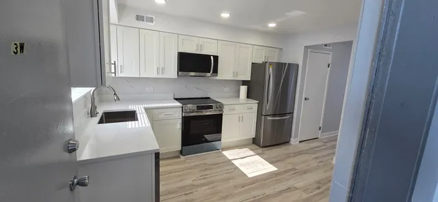 a kitchen with a refrigerator and a stove top oven