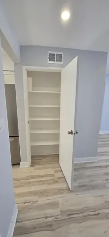 a view of walk in closet with empty racks