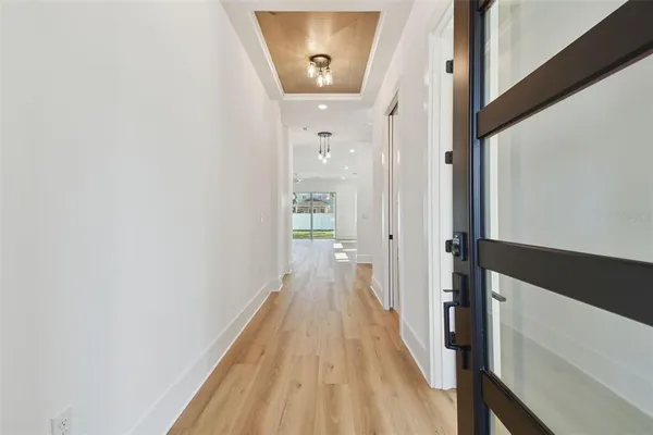 a view of a hallway with wooden floor and staircase