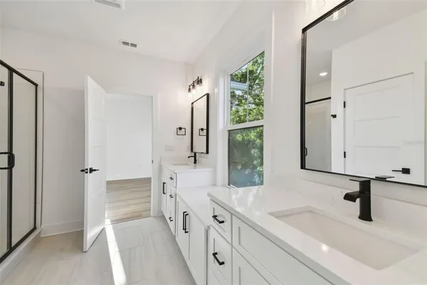 a spacious bathroom with a shower sink and mirror