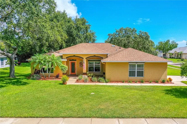 a front view of house with yard and trees in the background