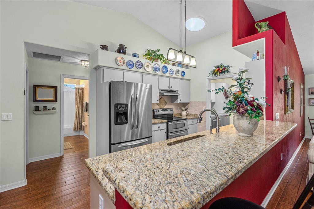 993 Appleview Way Port Orange, FL 32127 - Photo 10 of 46 a kitchen area with granite countertop a refrigerator dining table and chairs