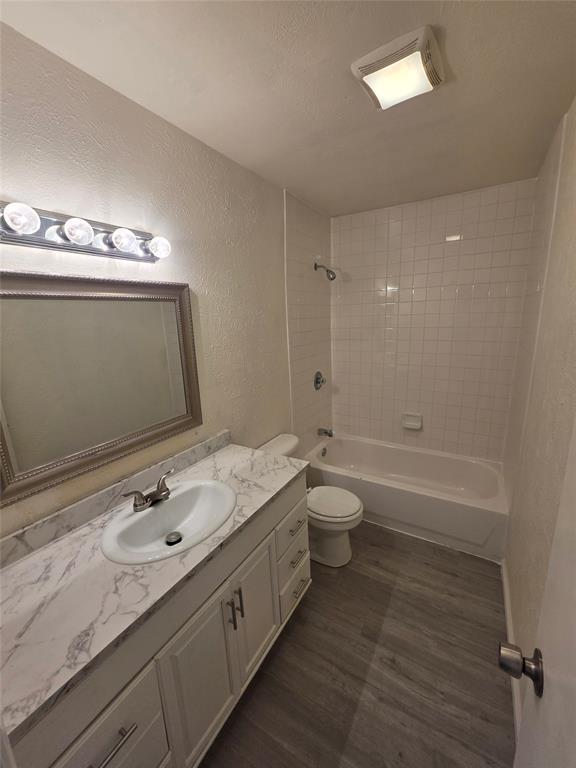9804 Sophora Circle Dallas, TX 75249 - Photo 11 of 12 a bathroom with a granite countertop sink a toilet and shower