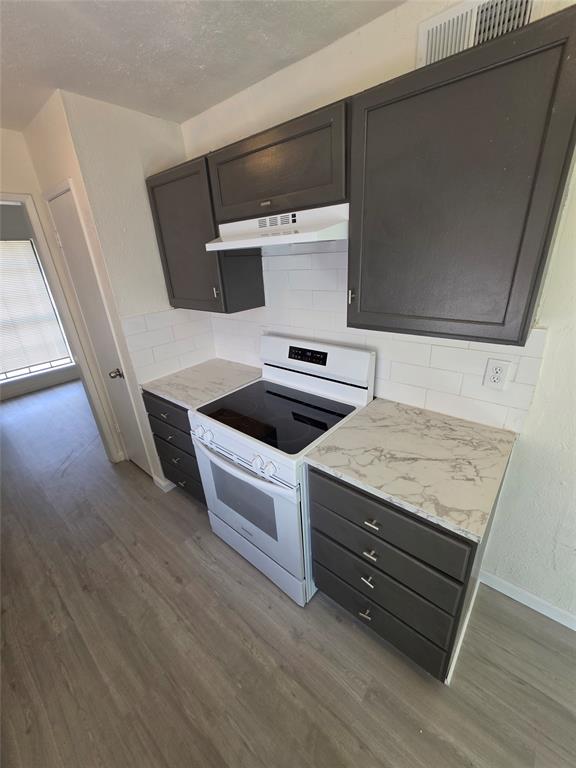 9804 Sophora Circle Dallas, TX 75249 - Photo 4 of 12 a room with wooden floor and utility room