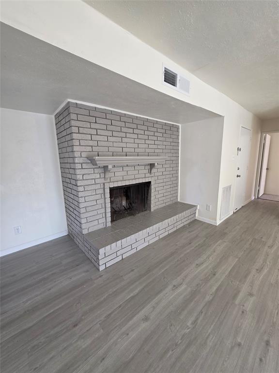 9804 Sophora Circle Dallas, TX 75249 - Photo 6 of 12 a view of an empty room with wooden floor and fireplace