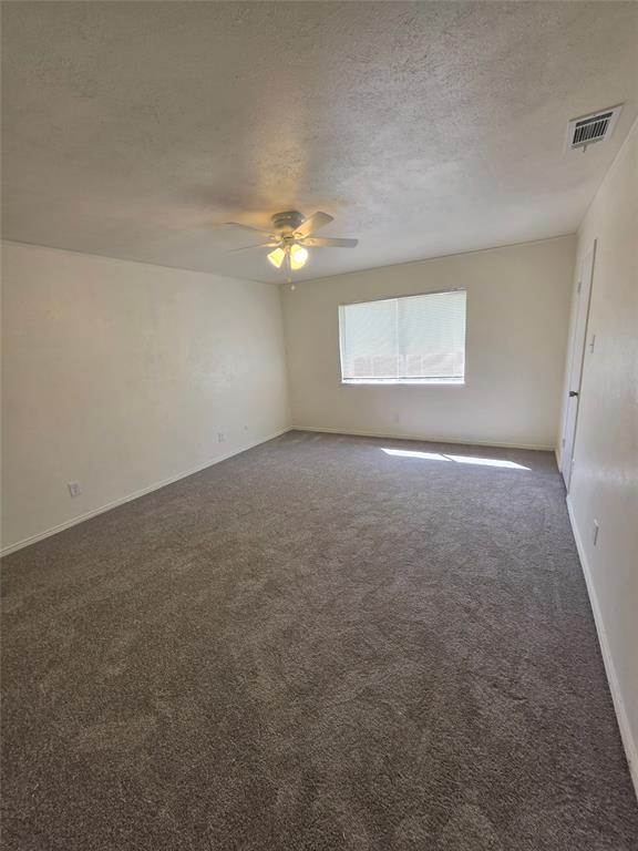 9804 Sophora Circle Dallas, TX 75249 - Photo 8 of 12 an empty room with windows and fan
