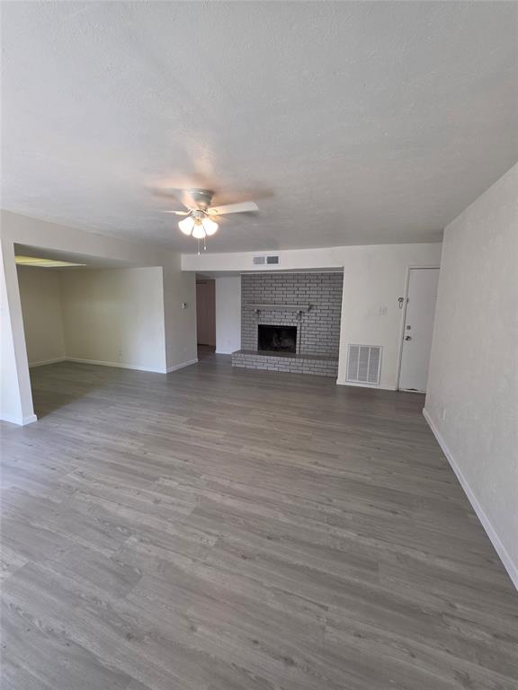 9804 Sophora Circle Dallas, TX 75249 - Photo 10 of 12 wooden floor in an empty room with a fireplace
