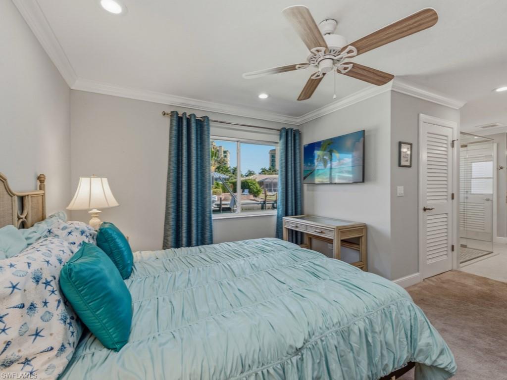 1081 Ruppert Road Marco Island, FL 34145 - Photo 17 of 39 a bedroom with a large bed and a chandelier