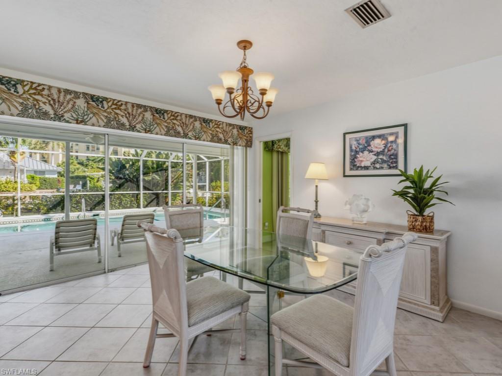 1081 Ruppert Road Marco Island, FL 34145 - Photo 9 of 39 a dining room with furniture a large window and a chandelier