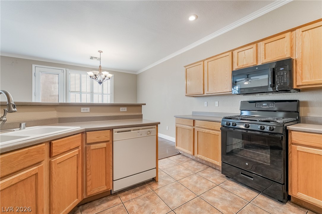 224 Positive Point Street Henderson, NV 89012 - Photo 14 of 44 Ample wooden cabinetry and ceramic tile flooring define this functional kitchen space.