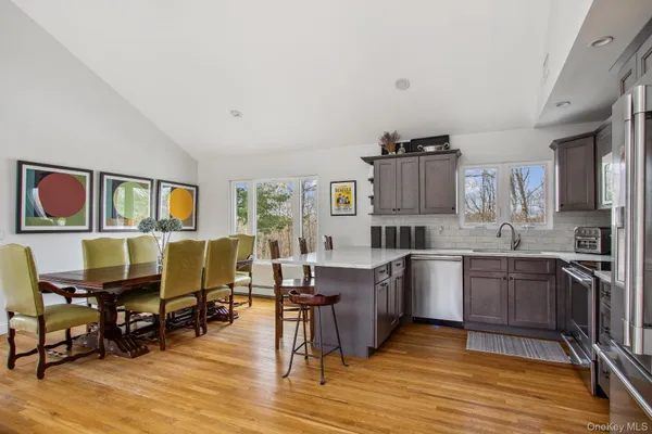 a living room with furniture wooden floor and kitchen view