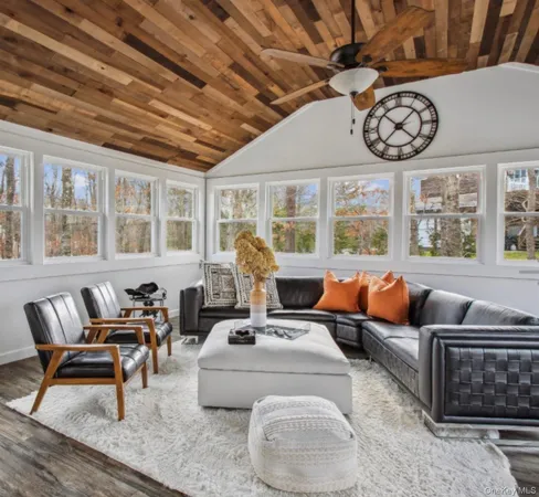 a living room with furniture a fireplace and a floor to ceiling window