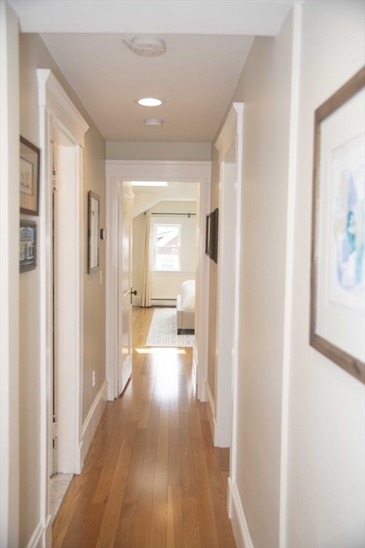 3 Chester Road, Unit 3 Belmont, MA 02478 - Photo 37 of 40 a view of a hallway with wooden floor a bathroom and a sink