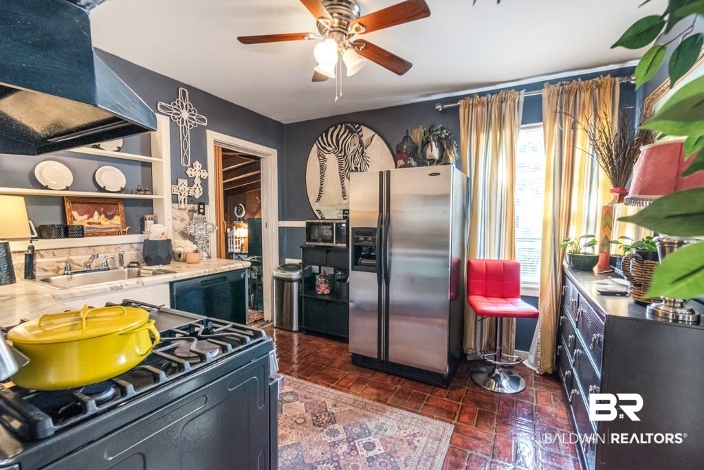 109 Esplanade Avenue Mobile, AL 36606 - Photo 28 of 45 Kitchen featuring black appliances, wall chimney range hood, light countertops, and a ceiling fan