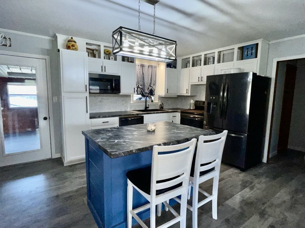 219 John Fuson Road Smithville, TN 37166 - Photo 42 of 84 a kitchen with stainless steel appliances granite countertop a table chairs a refrigerator and a sink