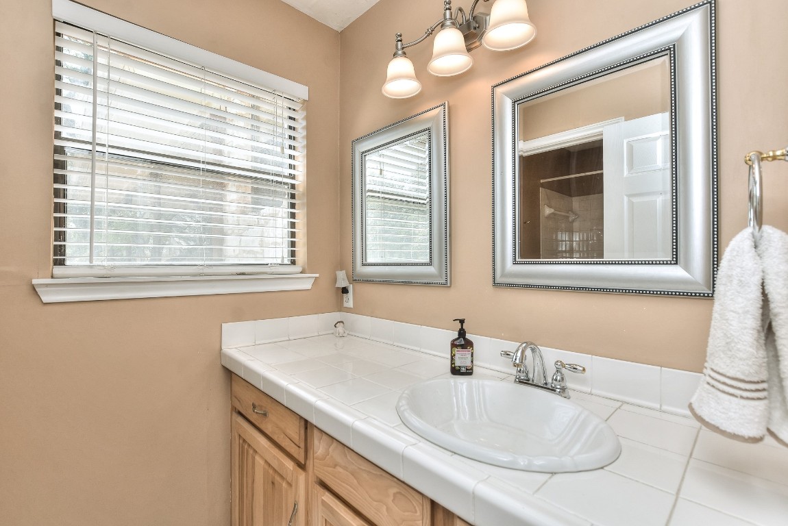 6724 Outer Avenue Leander, TX 78641 - Photo 15 of 40 a bathroom with a granite countertop sink and a mirror