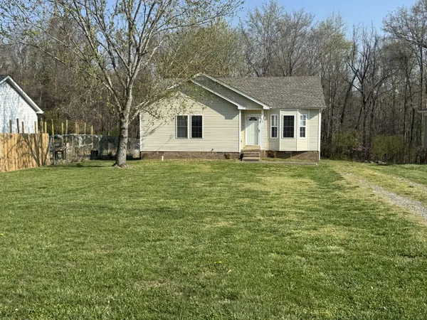 a house that has a tree in front of a white house
