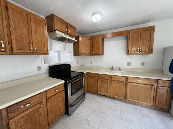 a kitchen with granite countertop a sink stainless steel appliances and cabinets