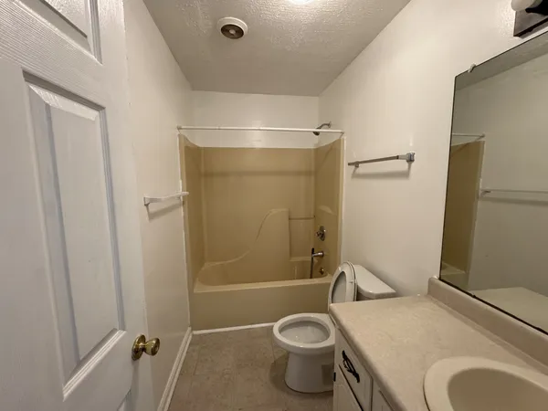 a bathroom with a granite countertop toilet and a sink