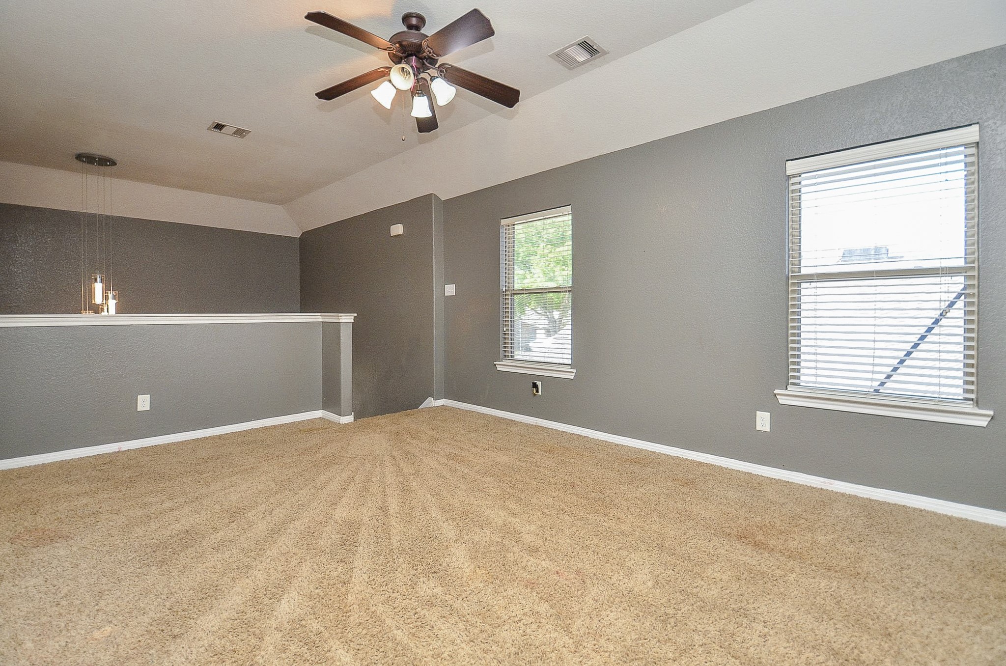 5411 Rio Drive Baytown, TX 77521 - Photo 21 of 30 Upper-level area with natural light and an open, versatile layout. The half-wall overlook with pendant lighting provides a view to the level below, enhancing the airy, loft-like feel, makes it ideal for a secondary living area, game area, home office, or flex space.