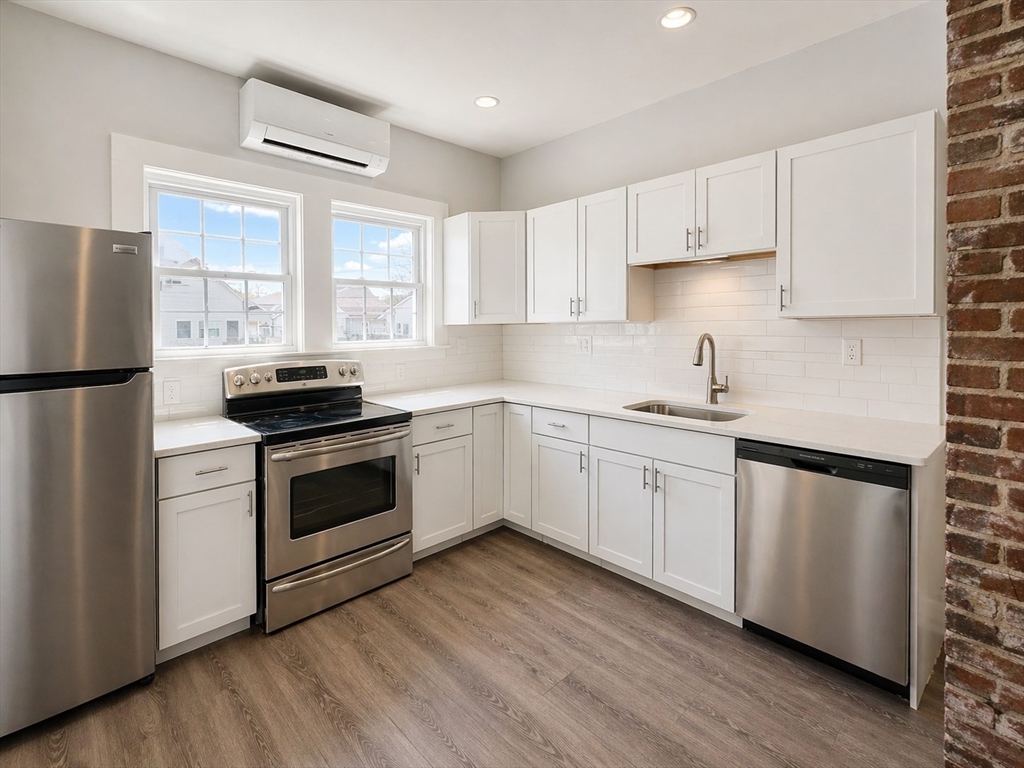 159 Parsons Street, Unit 2 Boston, MA 02135 - Photo 3 of 10 a white kitchen with sink a refrigerator and white cabinets