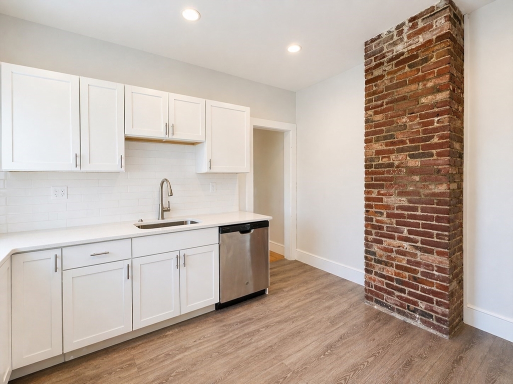 159 Parsons Street, Unit 2 Boston, MA 02135 - Photo 4 of 10 a kitchen with cabinets and wooden floor