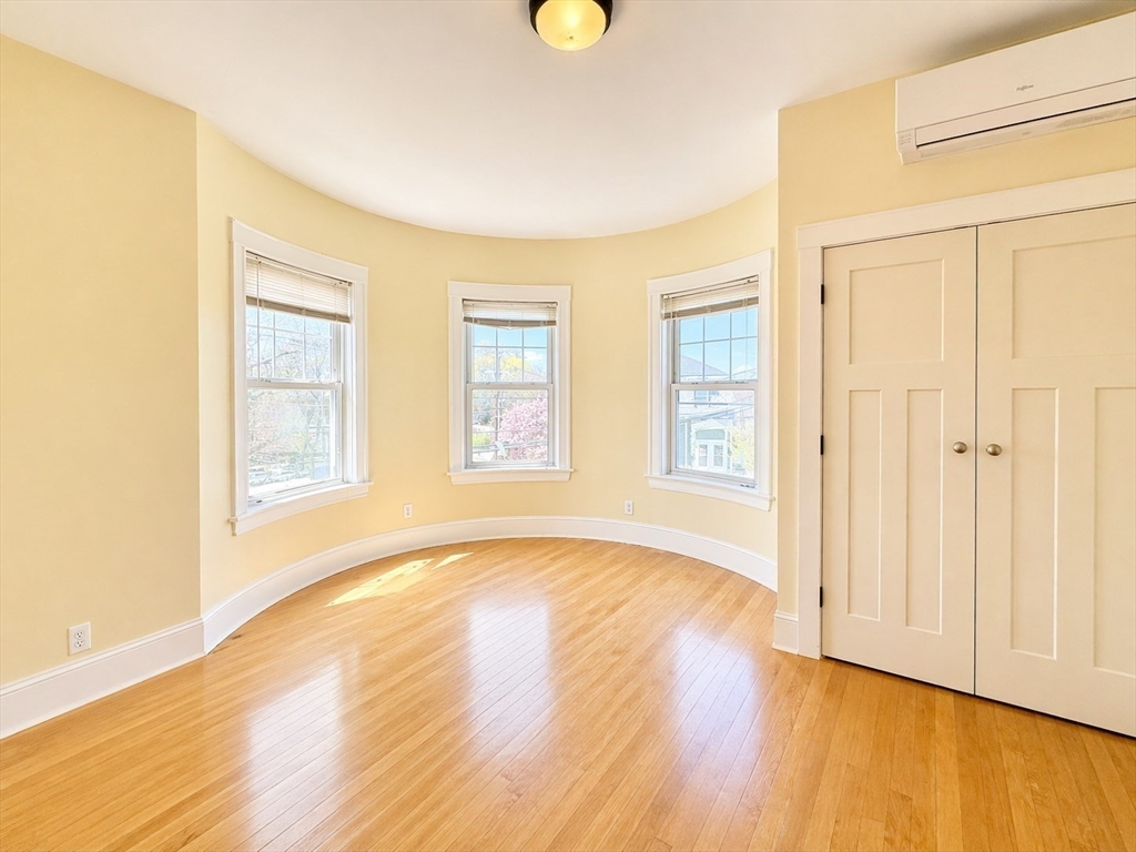 159 Parsons Street, Unit 2 Boston, MA 02135 - Photo 6 of 10 a view of an empty room with wooden floor and a window