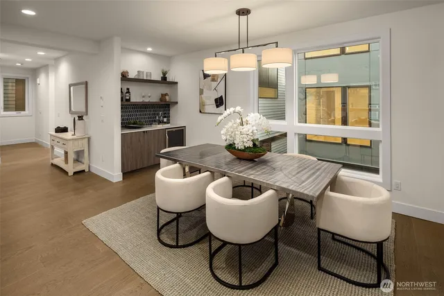 a kitchen with a dining table chairs sink and refrigerator