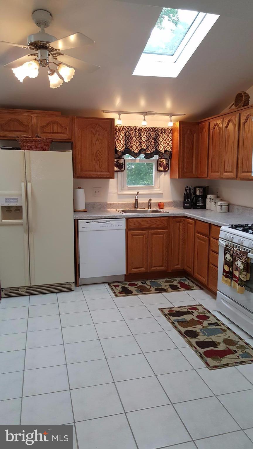 4111 Klausmier Road Baltimore, MD 21236 - Photo 9 of 28 a kitchen with kitchen island granite countertop a stove a sink and a refrigerator