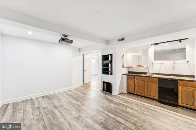 a view of kitchen island with stainless steel appliances kitchen island sink and wooden floor