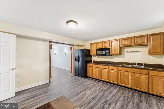 a view of a kitchen with wooden floor and a sink