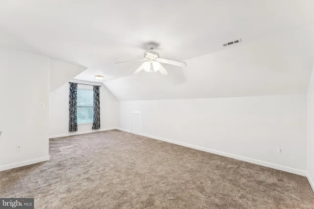 an empty room with closet and a ceiling fan