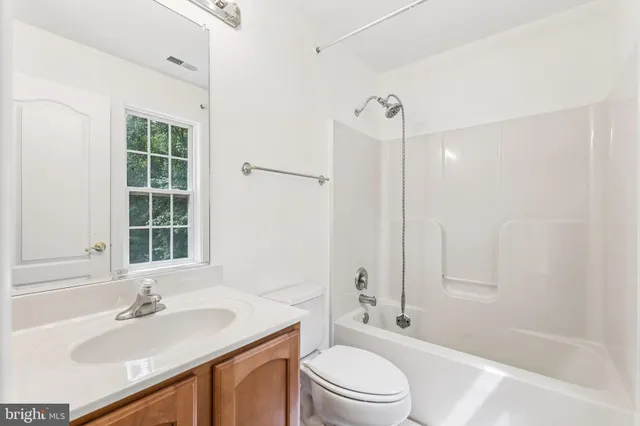 a bathroom with a sink a toilet and a large mirror